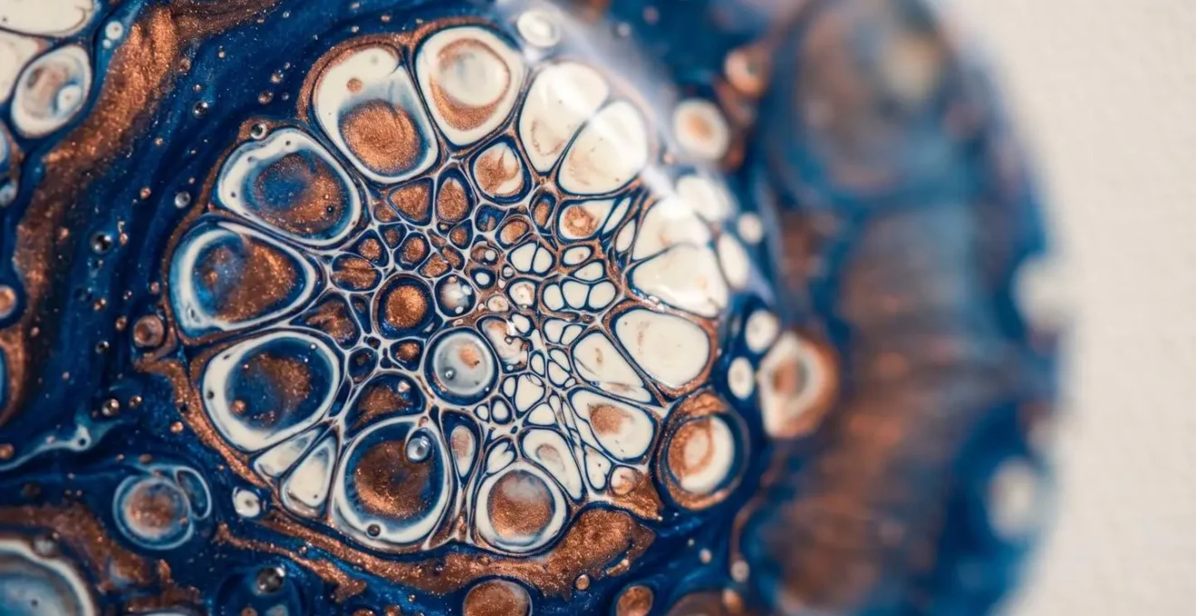 Macro close-up of acrylic paint cells forming through density interaction with visible surface tension